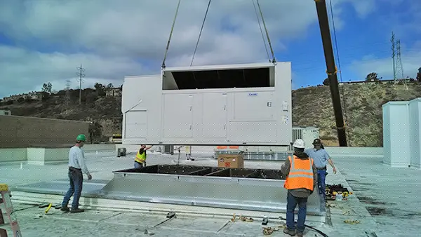 Workers installing an HVAC unit, depicting the installation process and equipment being used.