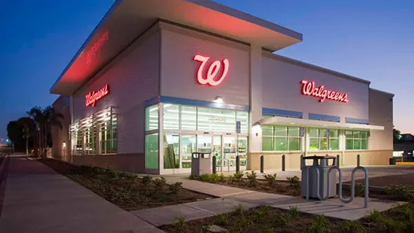 Walgreens building illuminated by neon lights at night, showcasing the store's signage and exterior